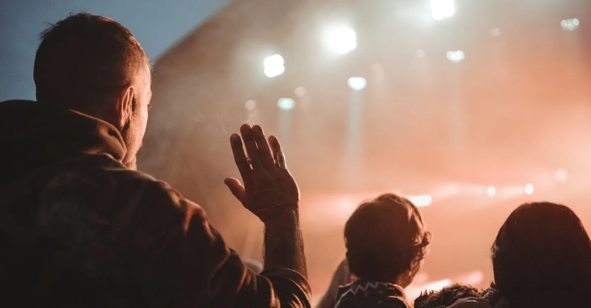 Une scène de concert animée avec des gens profitant de la musique en direct sous des lumières vives, capturant l'excitation de la vie nocturne.